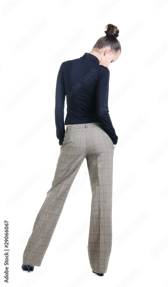 Beautiful young woman looking at wall. Rear view.