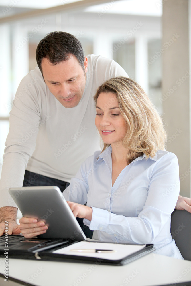 Office workers using electronic tab in the office Office workers using electronic tab in the office