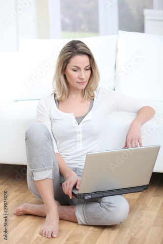 Blond woman using laptop computer at home