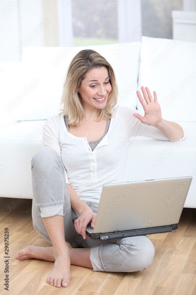 Blond woman waving at webcamera