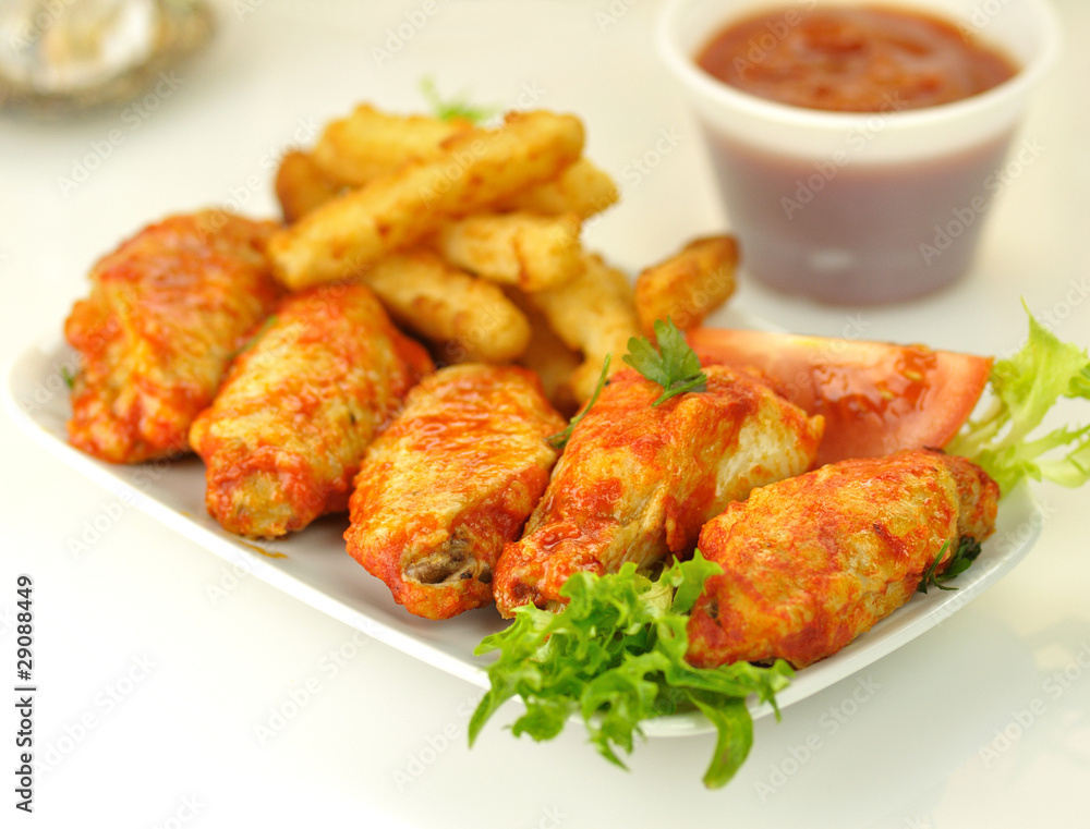 hot chicken wings with salad and fried potatoes hot chicken wings with salad and fried potatoes