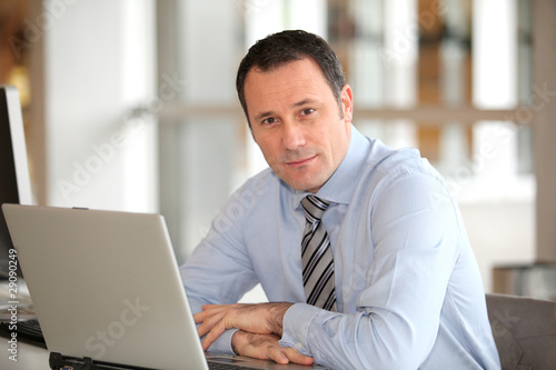 Portrait of businessman in front of laptop computer