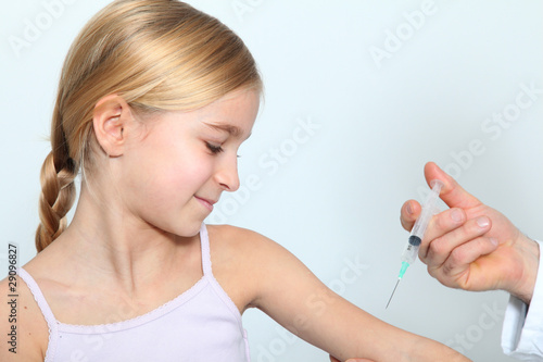 Fotografi Doctor doing vaccine injection to blond little girl