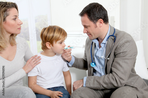 Doctor taking little boy's temperature