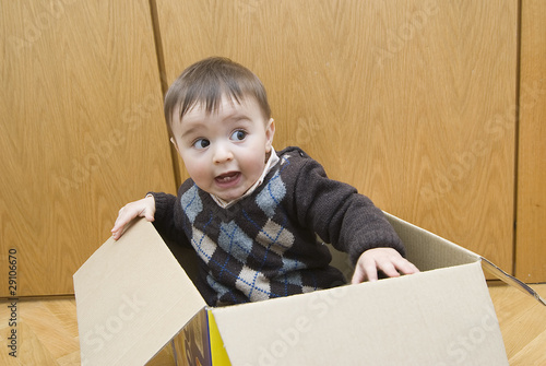 Bebé metido en una caja de cartón. photo