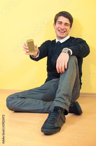 Portrait of a sitting smiling attractive young business man hold