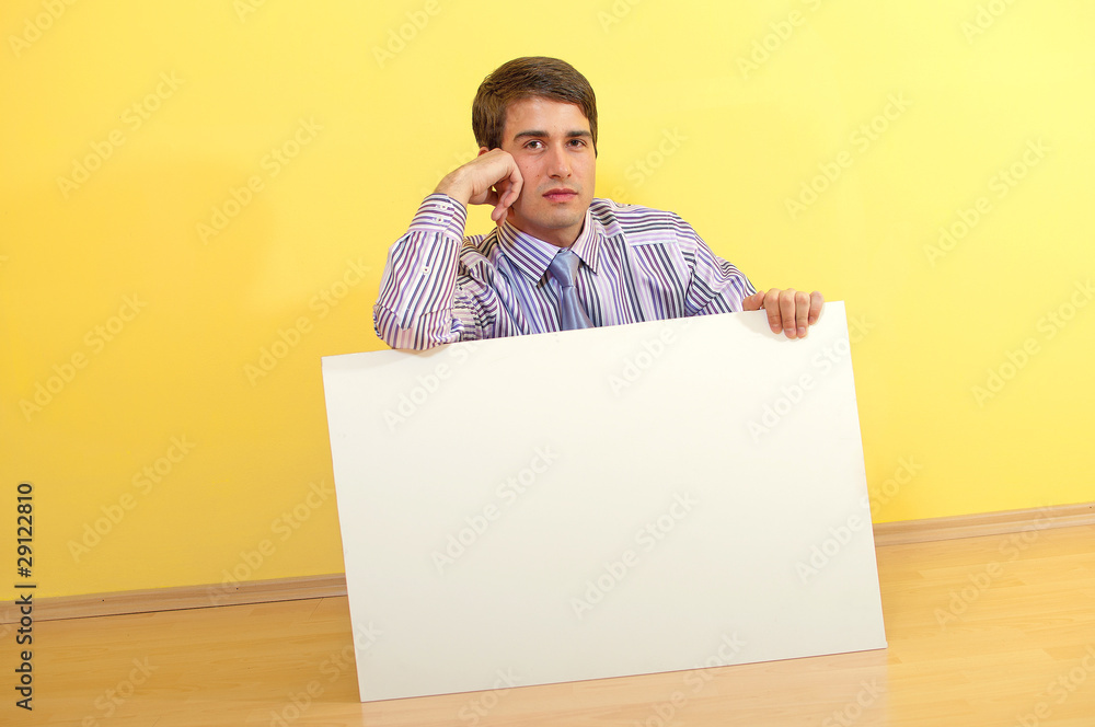 Portrait of a handsome young business man sitting behind a blank Portrait of a handsome young business man sitting behind a blank