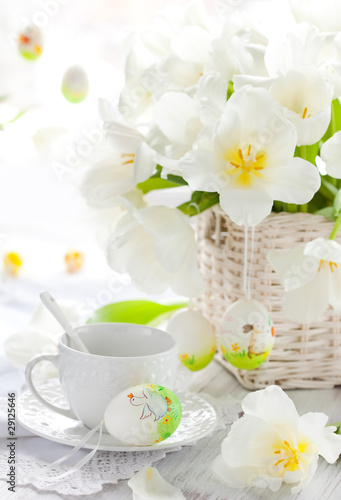 white tulips in a basket and easter eggs