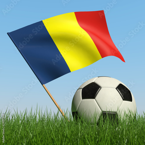 Soccer ball in the grass and flag of Romania.