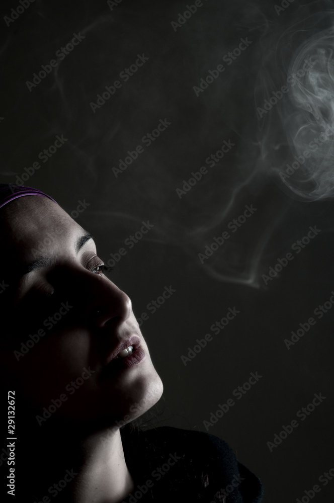 portrait of a girl who smokes on a black background portrait of a girl who smokes on a black background