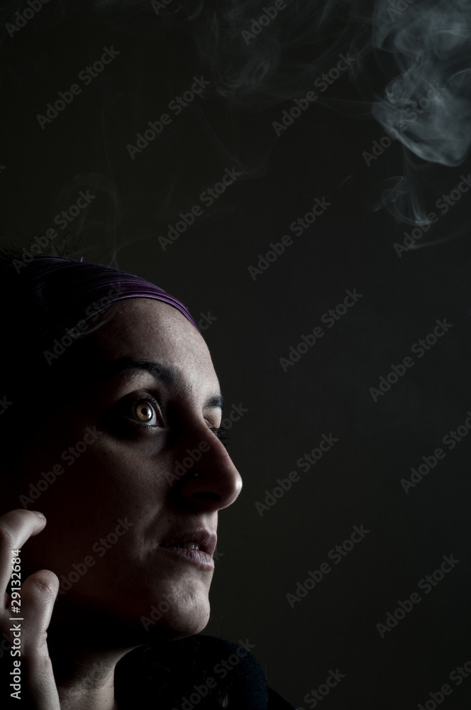 Fototapeta premium portrait of a girl who smokes on a black background