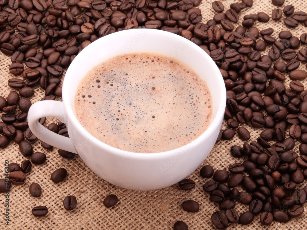 Coffee beans with cup on canvas Coffee beans with cup on canvas