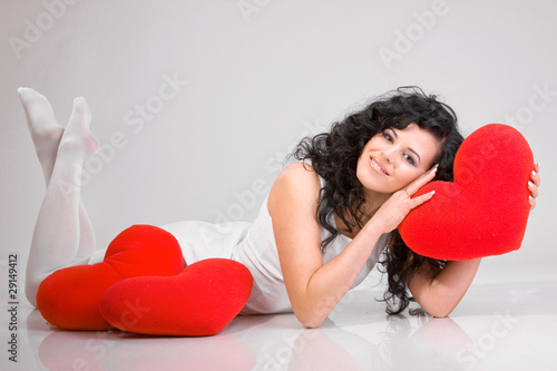 Romantic concept with girl and heart-shaped pillows