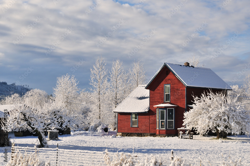 Red farmhouse with fresh winter snow and frost