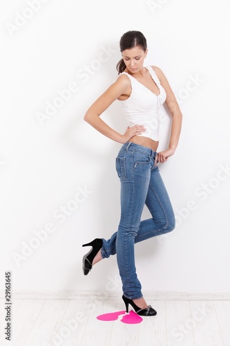Sexy lovelorn female trampling on pink paper heart