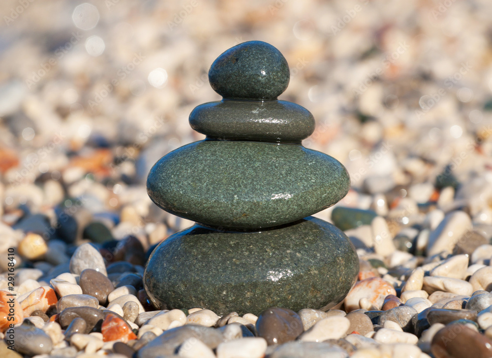 Pyramid made with wet pebble stones on the sea beach Pyramid made with wet pebble stones on the sea beach