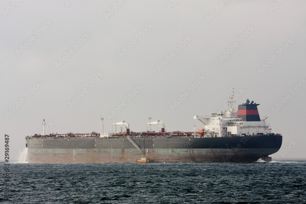Oil supertanker at sea with Pilot Boat