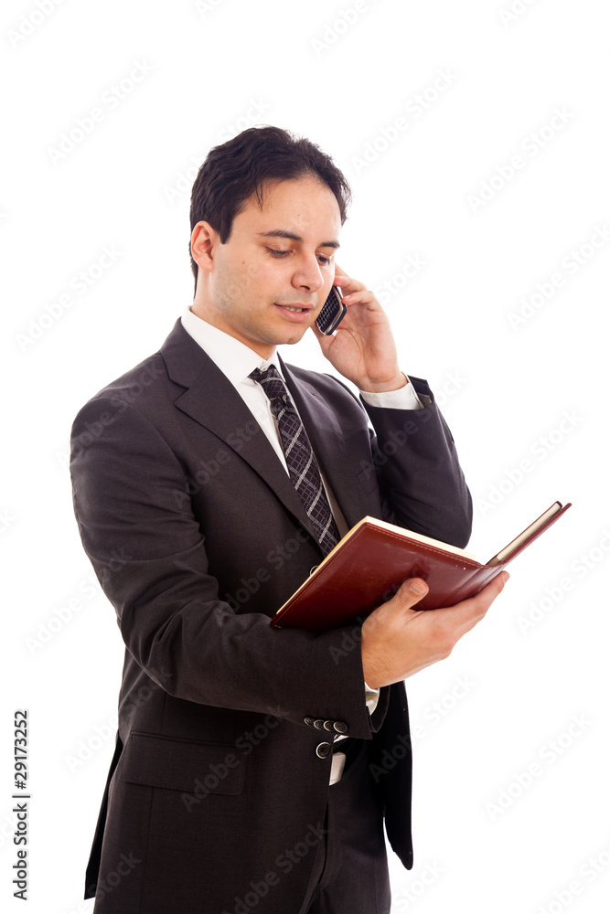 Businessman talking at the phone and looking at his agenda Businessman talking at the phone and looking at his agenda