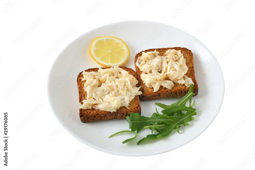 toasts with codfish and lemon on a plate