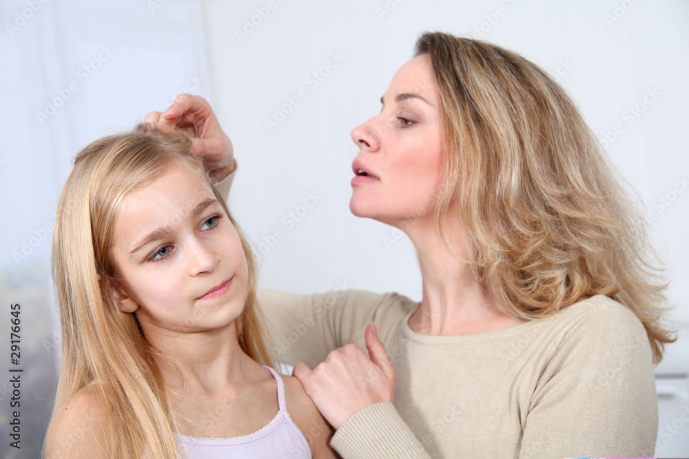 Mother treating daughter's hair against lice Mother treating daughter's hair against lice