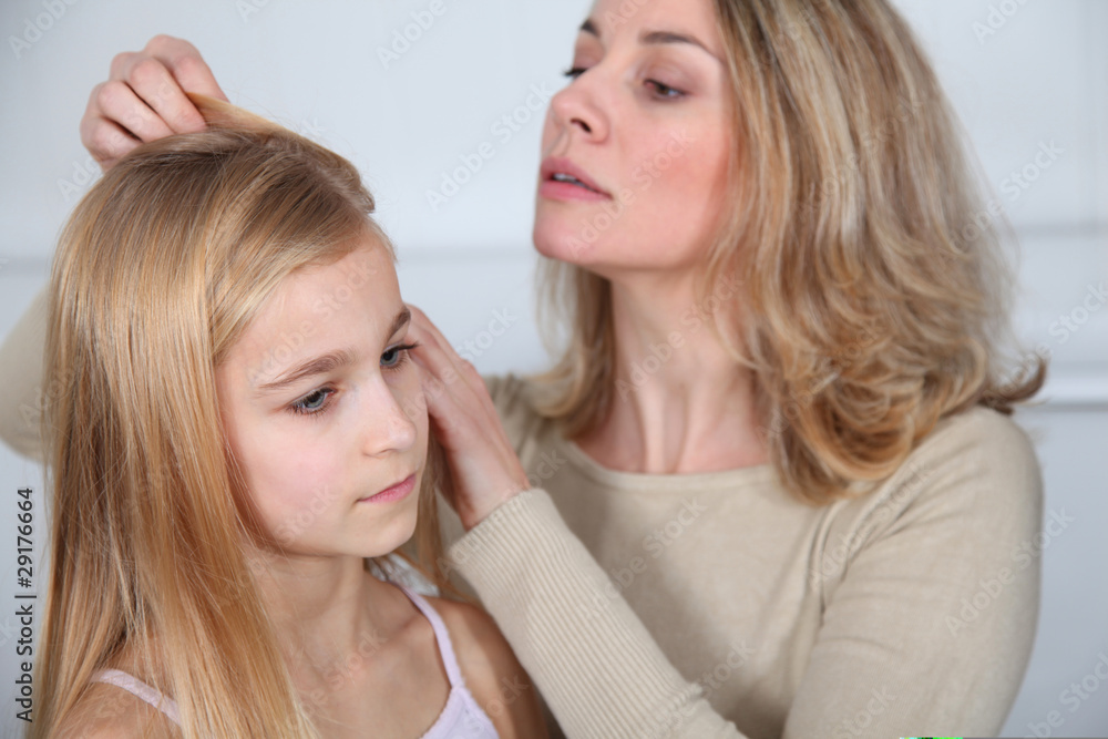Mother treating daughter's hair against lice Mother treating daughter's hair against lice