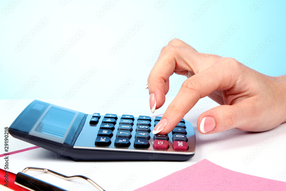 Fingers and calculator on blue background Fingers and calculator on blue background