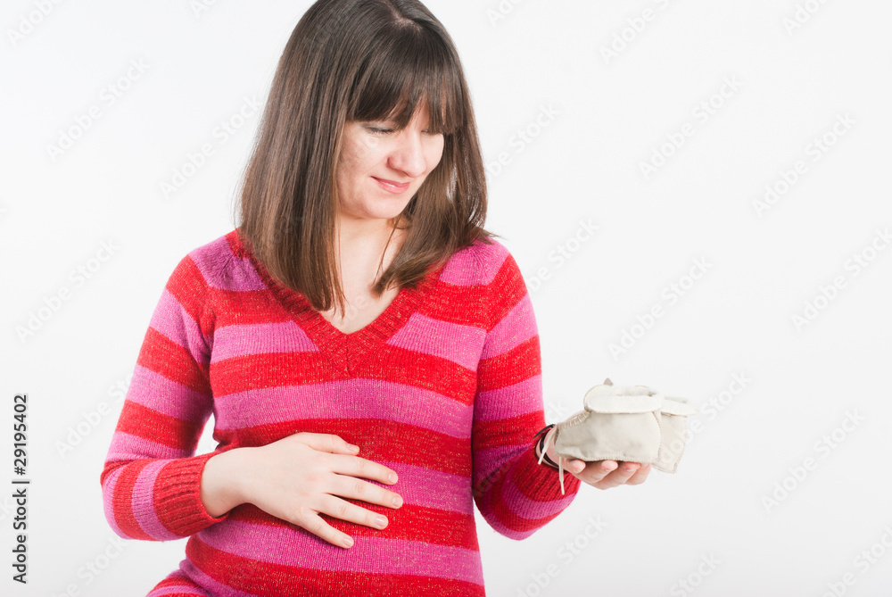 The pregnant woman looks at children's bootees, dreams The pregnant woman looks at children's bootees, dreams