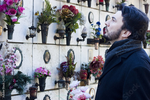 Mourning Man Standing on a Grave at the Cemetery
