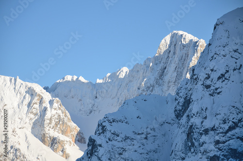 Snowcovered mountain peak with cross on top