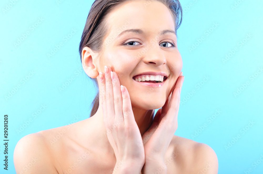 happy beautiful woman is touching her face and looking at camera happy beautiful woman is touching her face and looking at camera