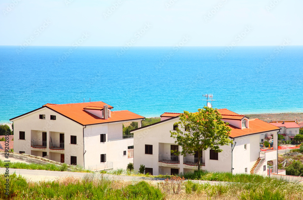Building of new two-storey white houses with brown roofs Building of new two-storey white houses with brown roofs