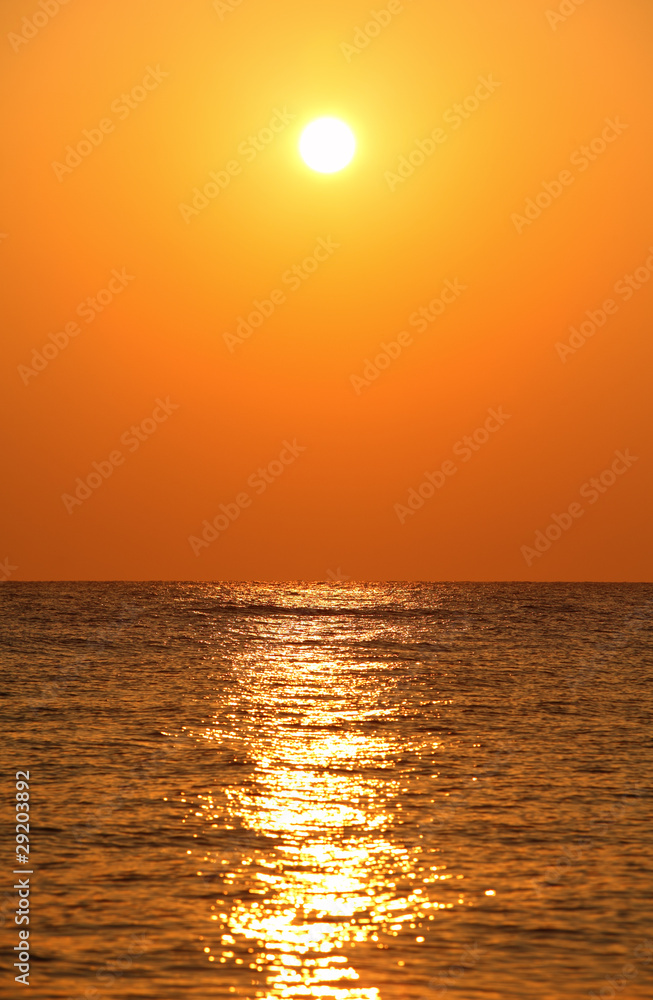 sun sets over horizon, sea, orange sun’s reflection in sea wat