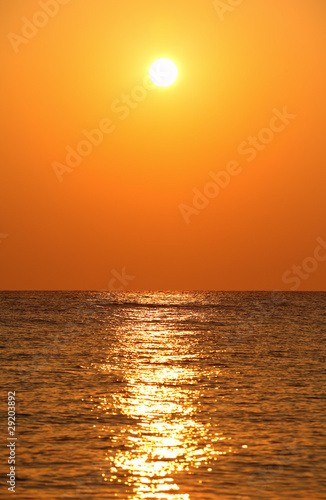 sun sets over horizon, sea, orange sun’s reflection in sea wat © Pavel Losevsky