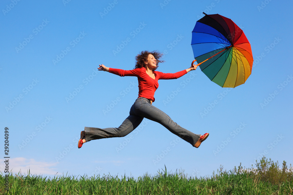 Girl jumping with umbrella in his hand against blue sky Girl jumping with umbrella in his hand against blue sky