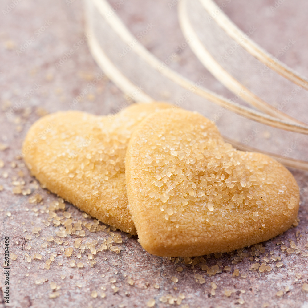 Closeup of two heart shaped cookies with brown sugar
