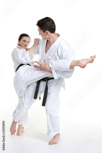 Karate. Young girl and a men in a kimono with a white background