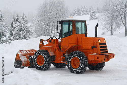 orange snow plows to work clearing the snow from the road