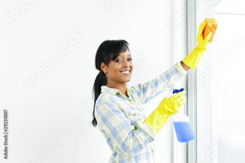 Smiling woman cleaning windows photo