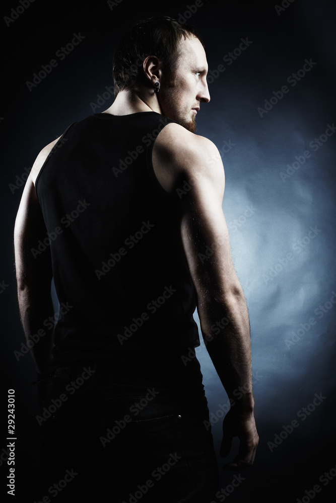 The muscular male back on black background