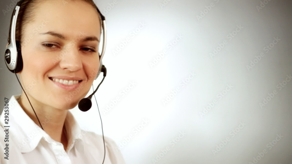 Woman with headset showing thumb up sign, grey background Woman with headset showing thumb up sign, grey background