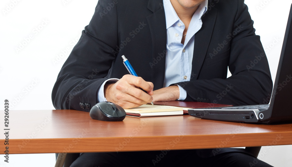 Businessman writing on the agenda in his office Businessman writing on the agenda in his office