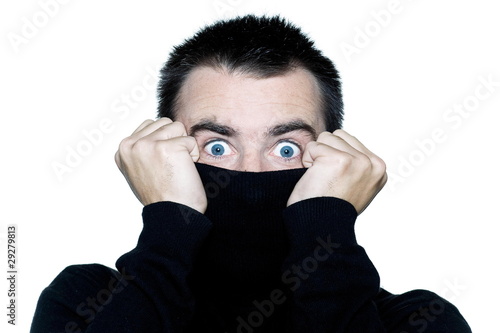 man hiding behind his turtle polo neck schock surprised