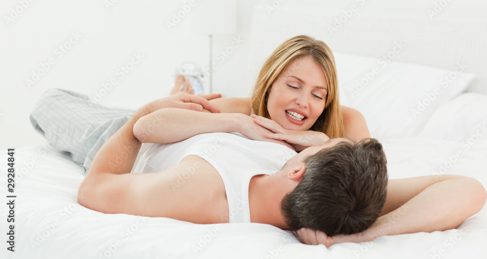 Lovely pairs lying down together in their bed at home Lovely pairs lying down together in their bed at home
