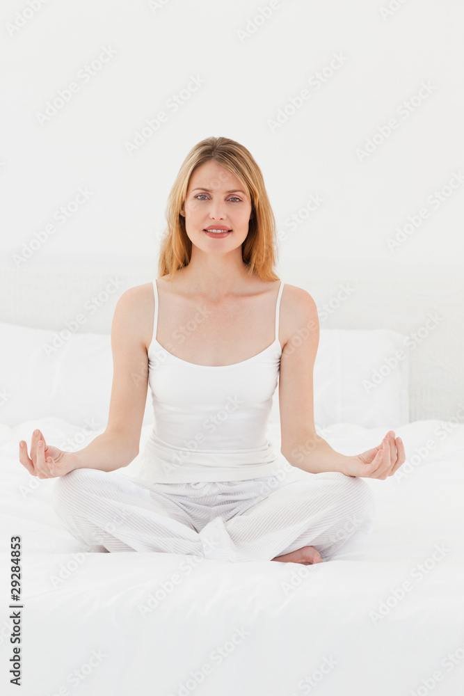 Woman practice yoga on her bed Woman practice yoga on her bed