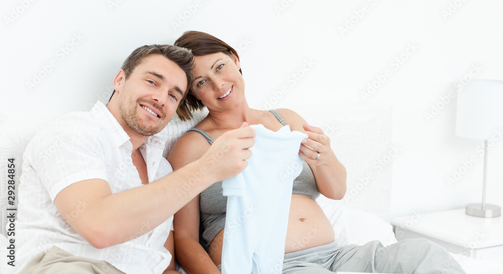 Young futur parents with chlidrens clothes Young futur parents with chlidrens clothes