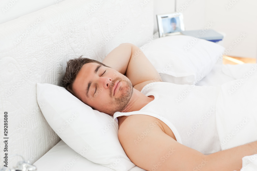 A relaxed man in his bed before waking up A relaxed man in his bed before waking up