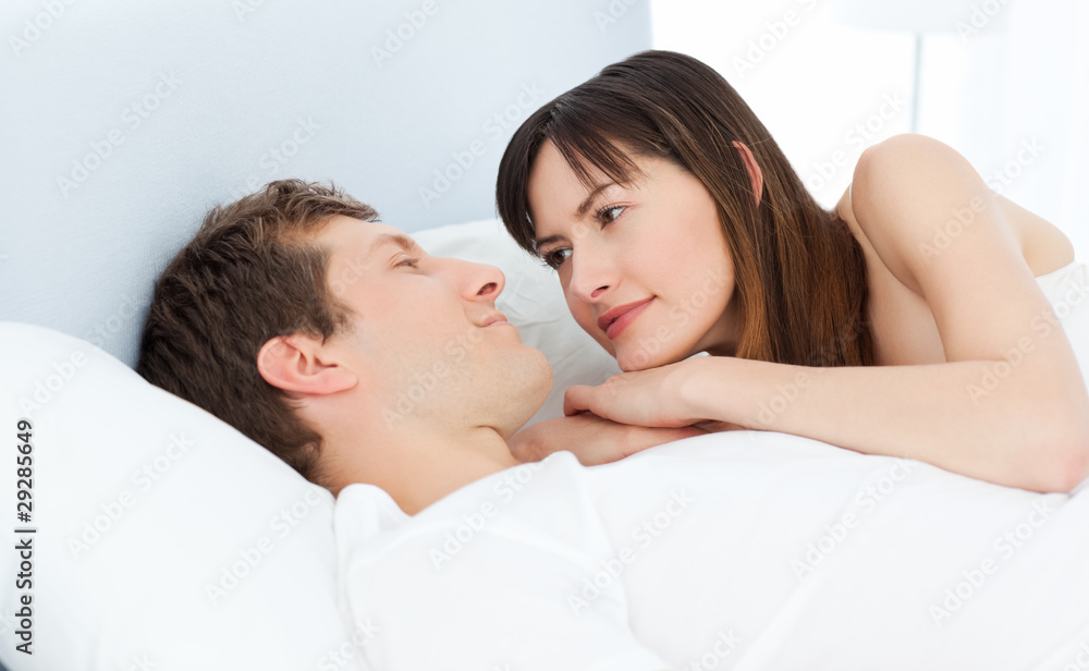 Happy couple lying down together on their bed Happy couple lying down together on their bed
