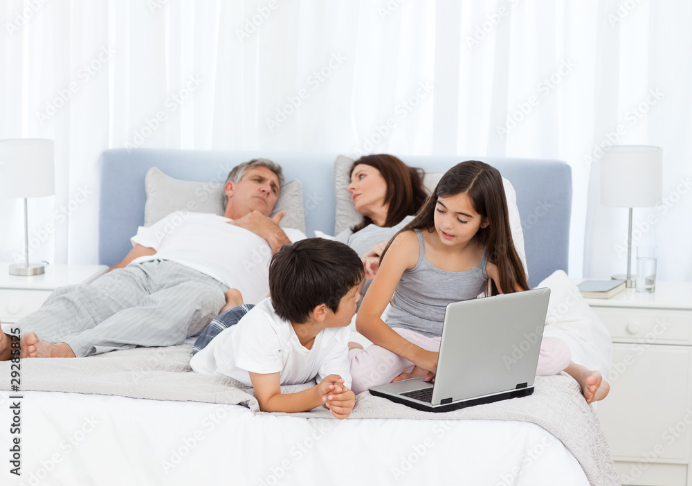 Childrens looking at their laptop while parents are talking Childrens looking at their laptop while parents are talking