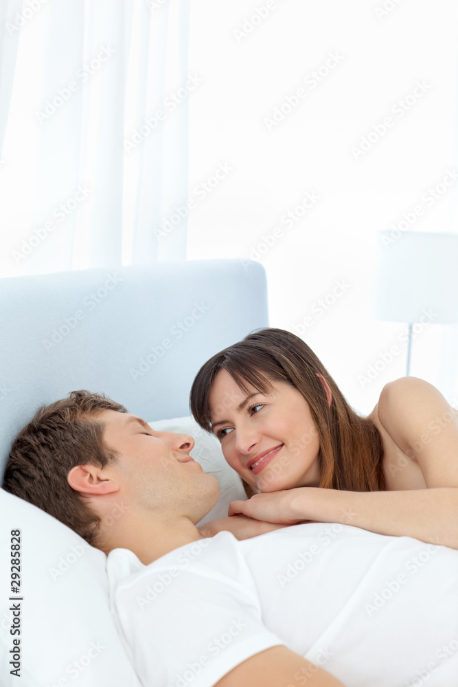 Happy couple lying down together on their bed Happy couple lying down together on their bed