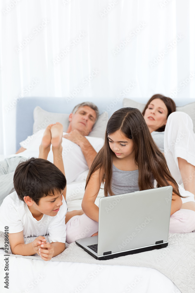 Childrens looking at their laptop while parents are talking Childrens looking at their laptop while parents are talking
